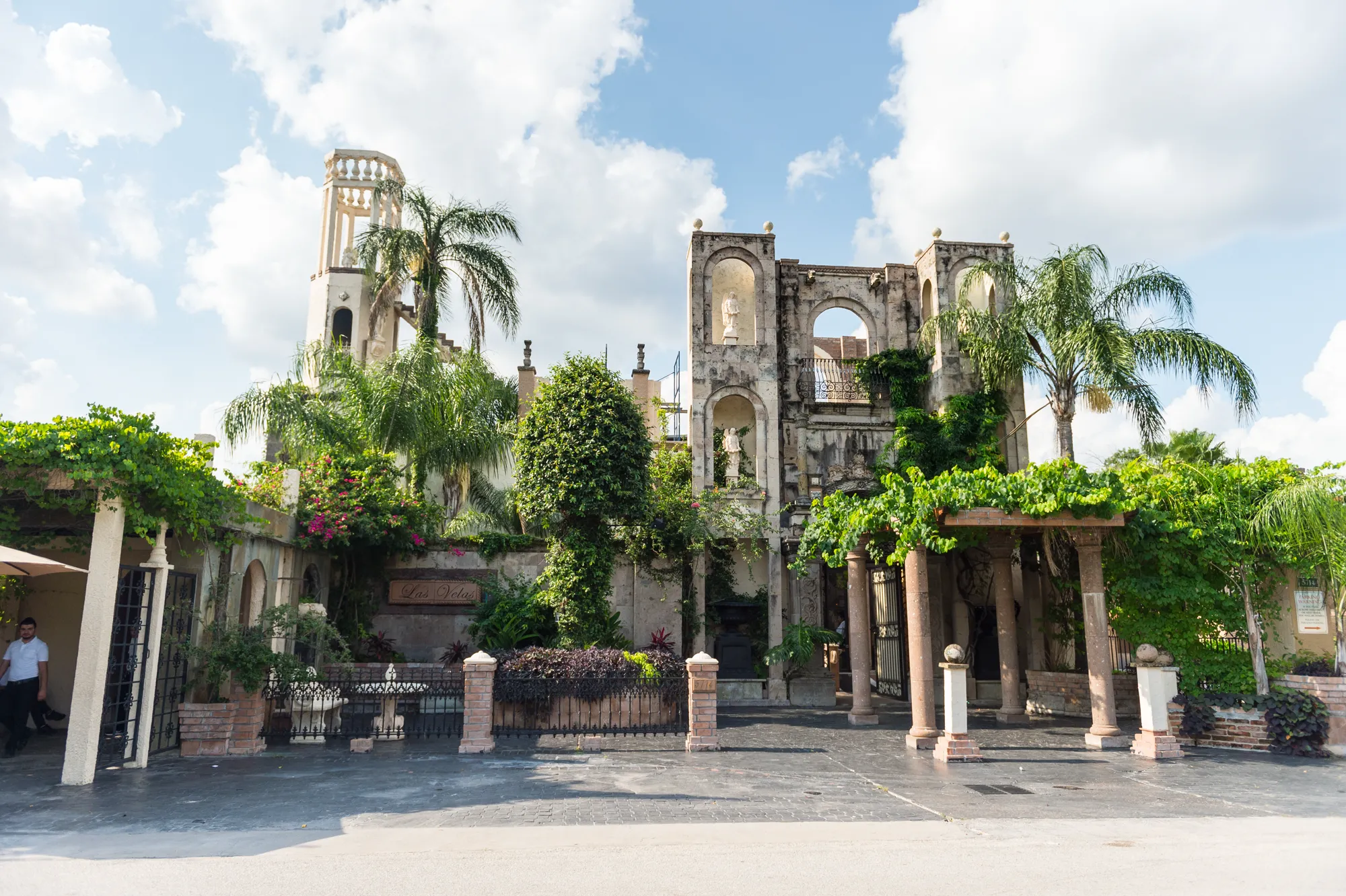 The front façade and bell tower with palms
